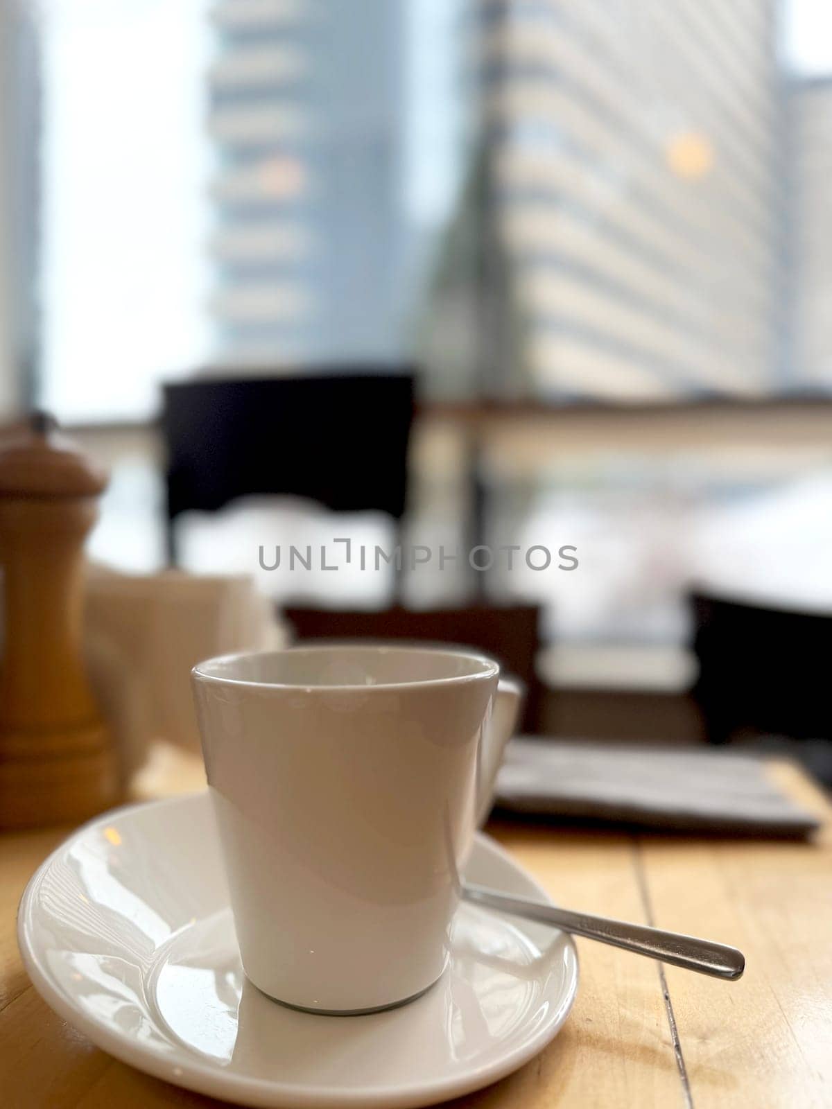 white coffee cup and saucer on the table on a blurred background.