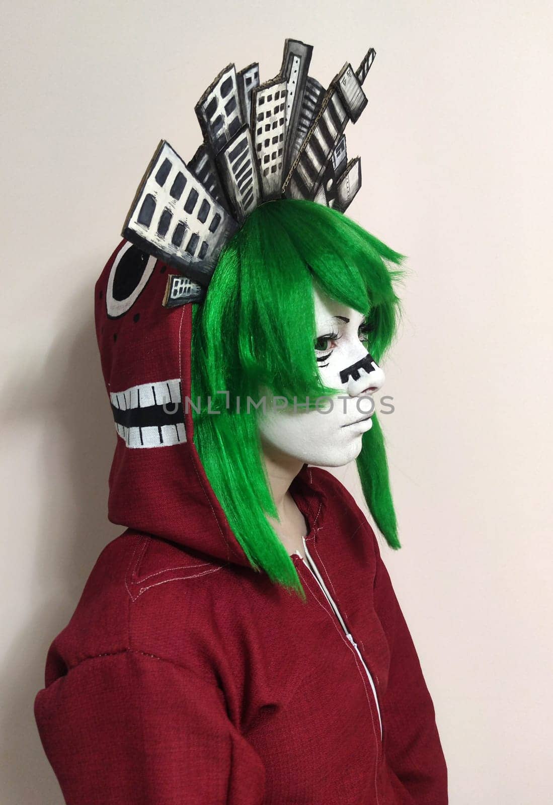 teenage girl in a green wig in an anime Gumi costume for cosplay, side view