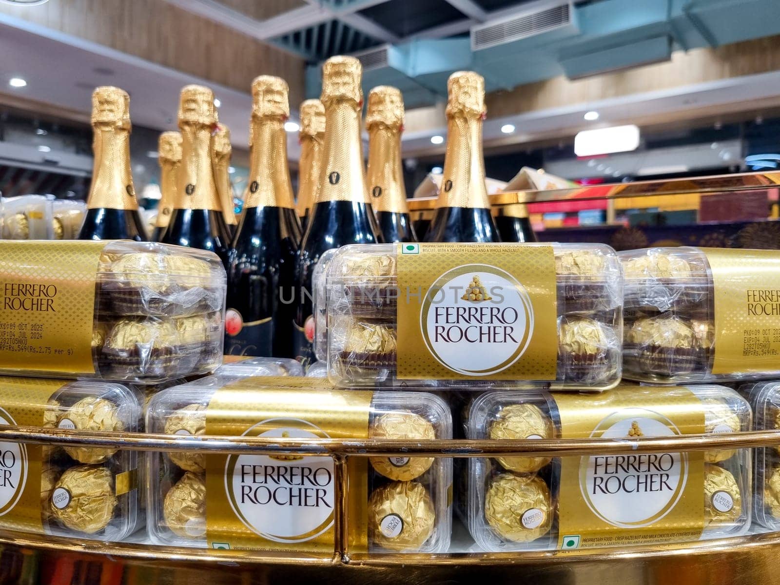 Delhi, India - 7th Dec 2023: Boxes of famous Ferrero Rocher placed on a shelf with champagne bottles showing this celebration chocolate