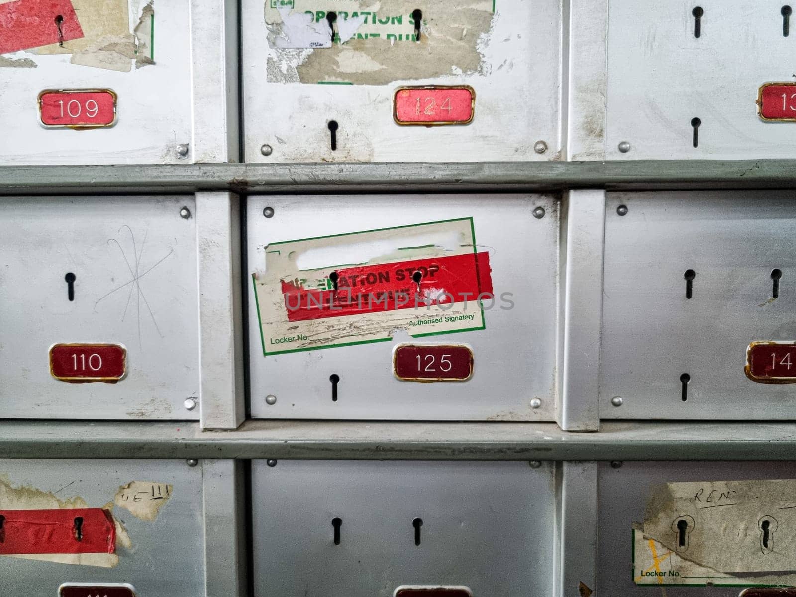 Dirty grungy bank lockers with pad locks and stickers showing non payment and foreclosure by bank