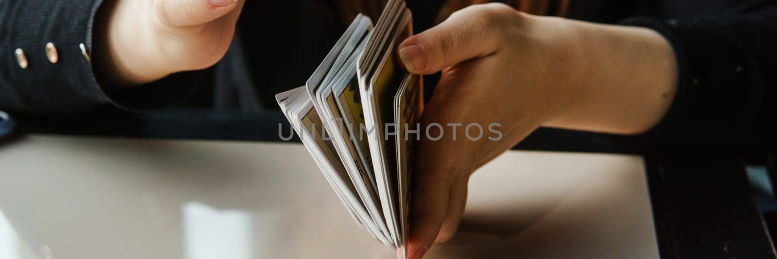 TVER, RUSSIA - FEBRUARY 11, 2023. Tarot cards, Tarot card divination, esoteric background. A woman makes a layout on the cards at the table. Divination, predictions on tarot cards