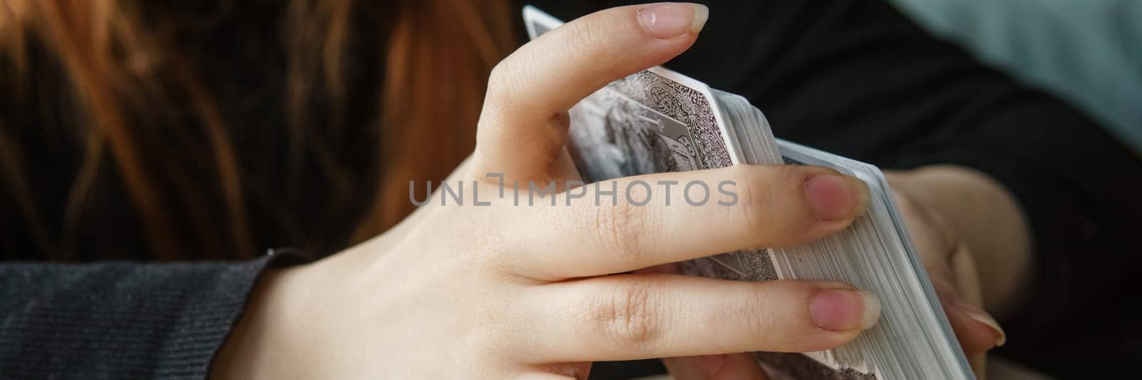 TVER, RUSSIA - FEBRUARY 11, 2023. Tarot cards, Tarot card divination, esoteric background. A woman makes a layout on the cards at the table. Divination, predictions on tarot cards