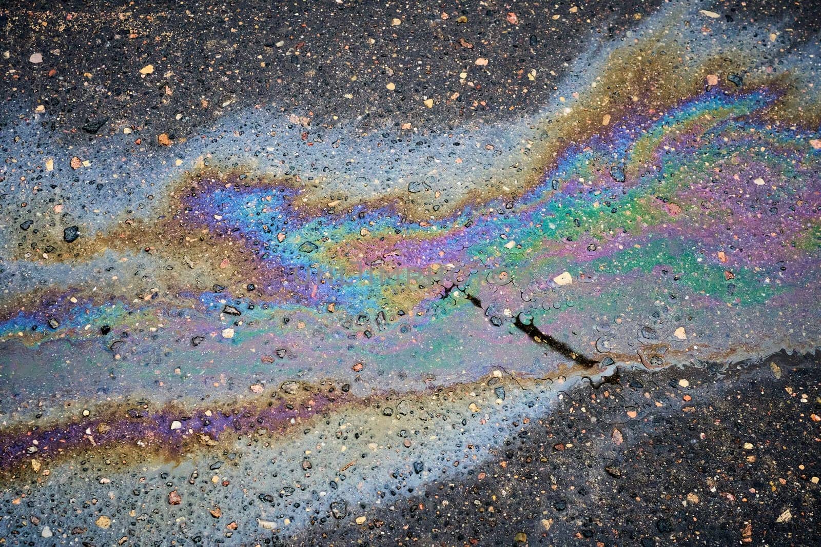 A pattern of brightly colored oil residues on a wet road