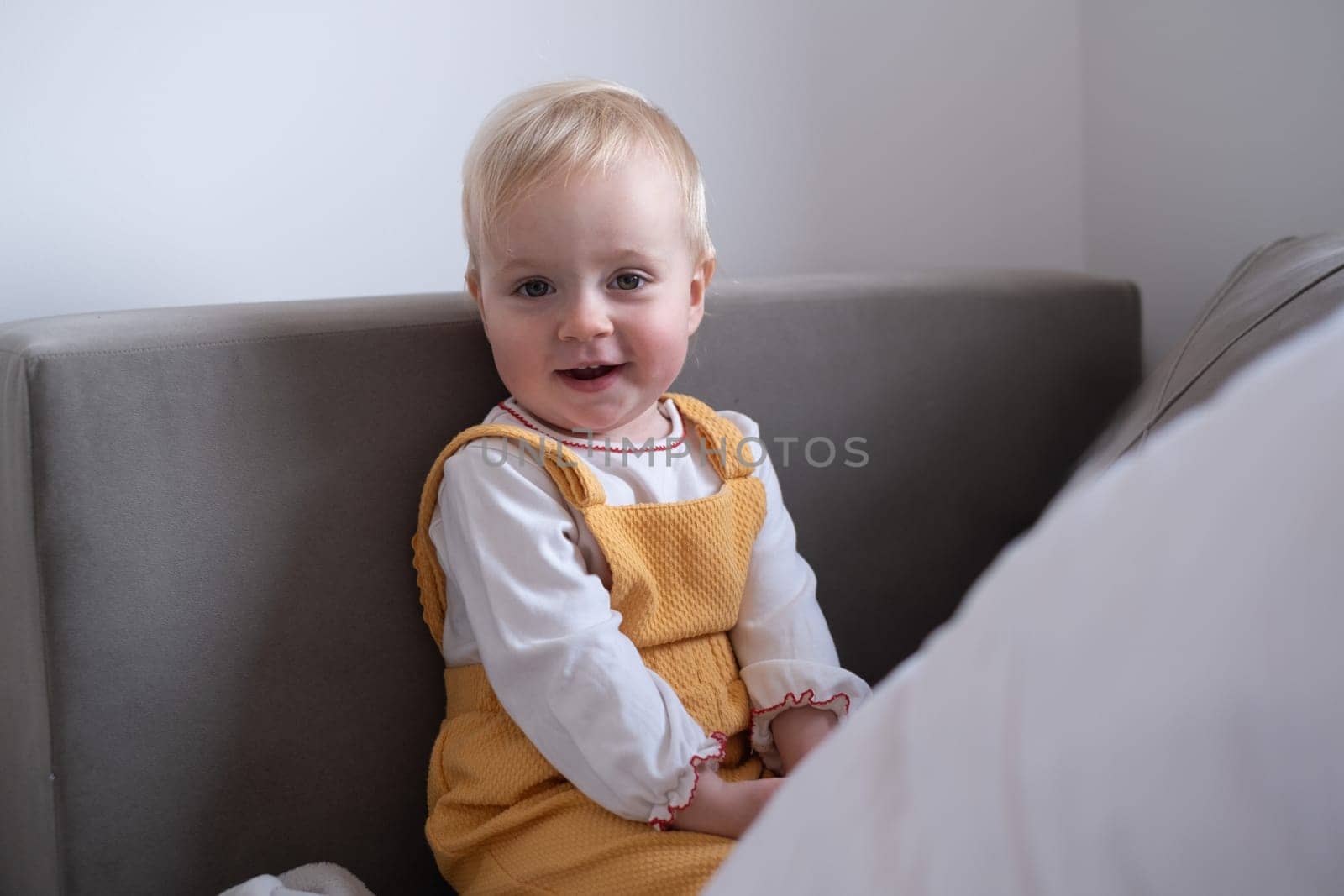 Portrait Of Happy caucasian Baby Girl sitting on a sofa