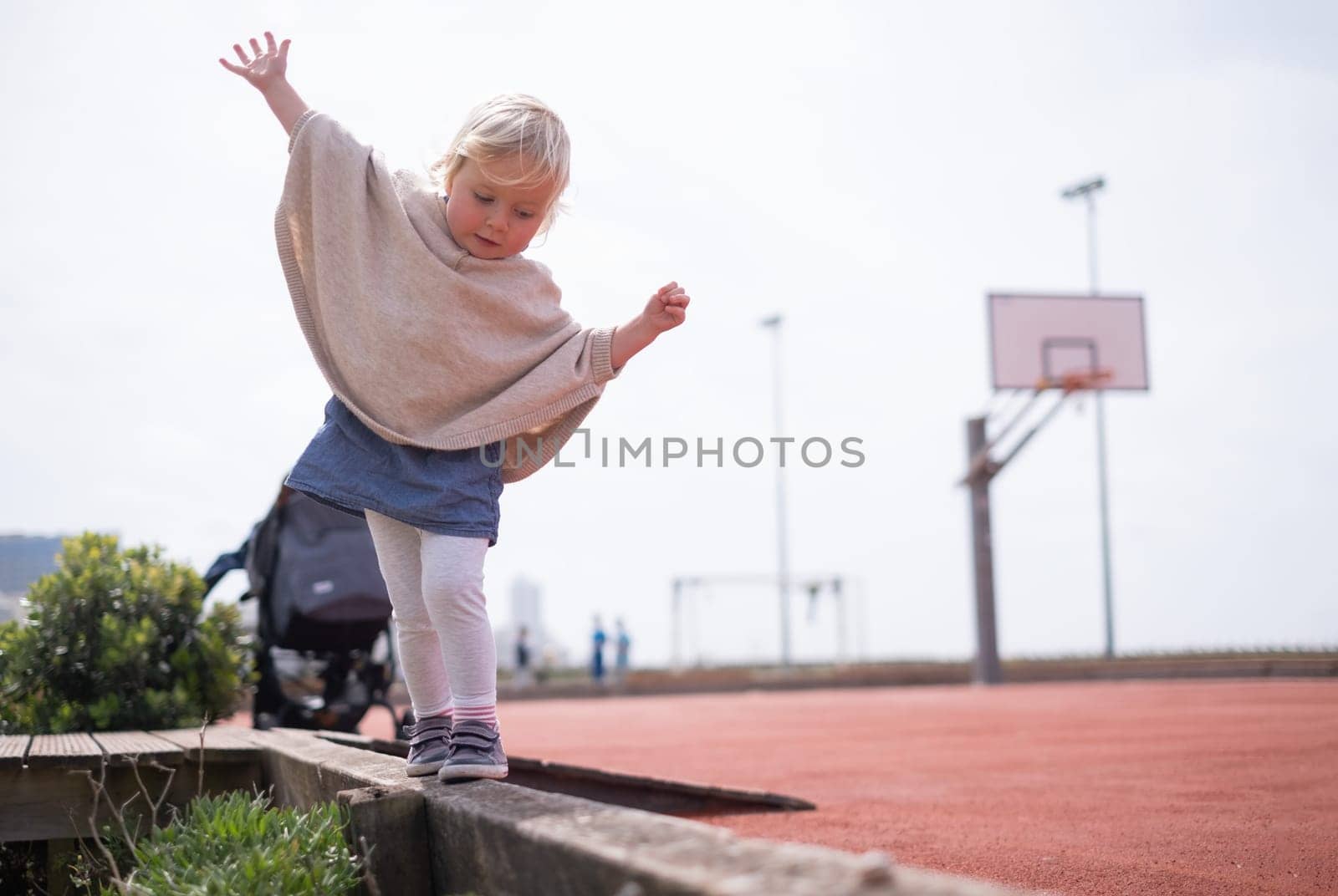 Little caucasian girl walking trying to balance
