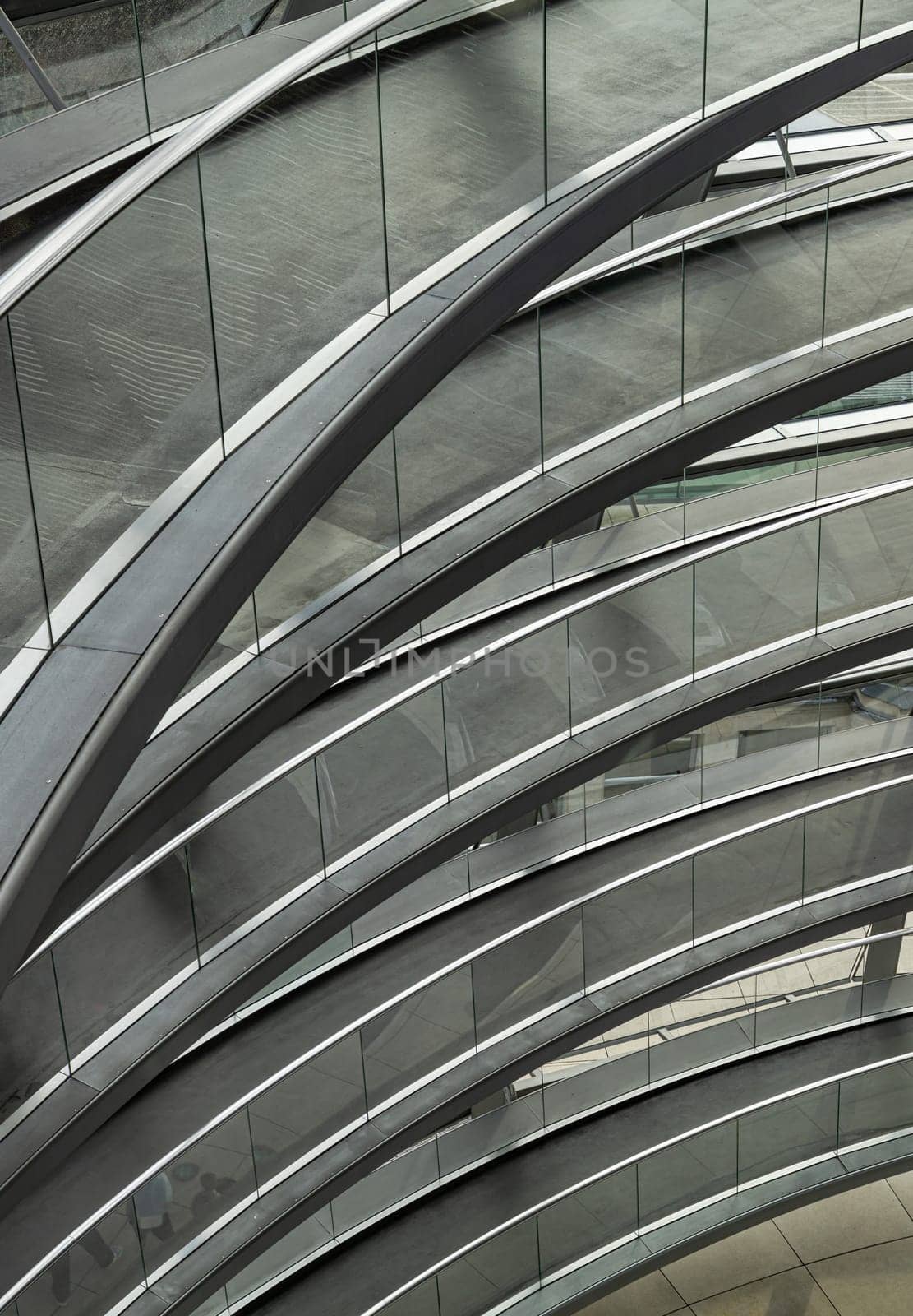 Berlin, Germany - Dec 20, 2023 - A curved walkway stretches in spirals upwards on top inside the glass dome constructed of the Reichstag building. Contemporary architecture of the Cupola of the Reichstag dome, a major tourist attraction of the berlin city, Space for text, Selective focus.