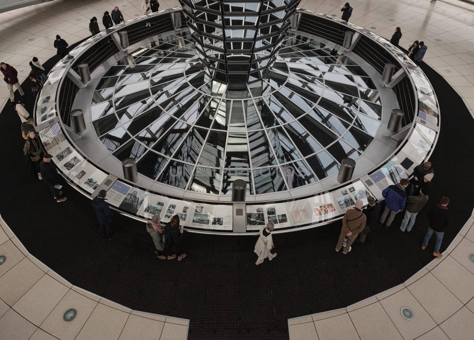 Berlin, Germany - Dec 20, 2023 - Several tourists visitor inside the futuristic glass dome of Reichstag building. Contemporary architecture of the Cupola of the Reichstag dome, a major tourist attraction of the berlin city, Copy space, Selective focus.