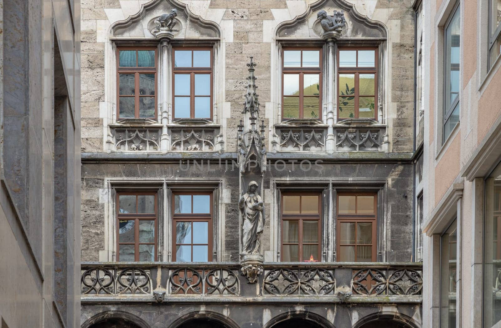 Munich, Germany - Dec 21, 2023 - Sandstone Building with many Windows is Decorated with Statues with Gothic style. Exterior architecture design of famous New Town Hall (Neue Rathaus) on Marienplatz square in Munich, Space for text, Selective focus.