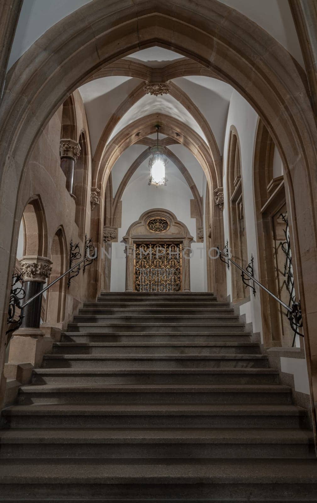Munich, Germany - Dec 21, 2023 - Gothic architectural style with arches of famous New Town Hall (Neues Rathaus) on Marienplatz square in Munich. Beautiful Corridor with Staircase, Ceiling, Pillars and Lamp, Copy space, Selective focus.