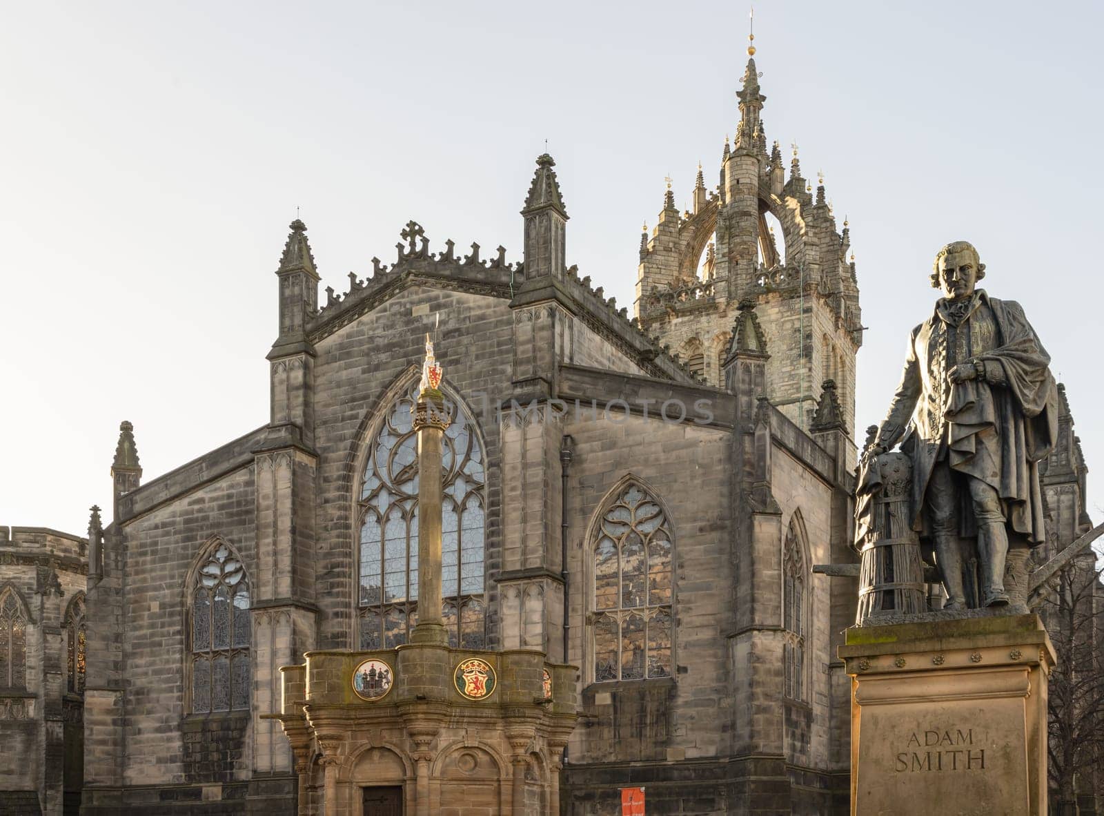 Edinburgh, Scotland - Jan 18, 2024 - The monument bronze statue of Adam Smith in front of St Giles' Cathedral or the High Kirk of Edinburgh. Copy space, Selective focus.
