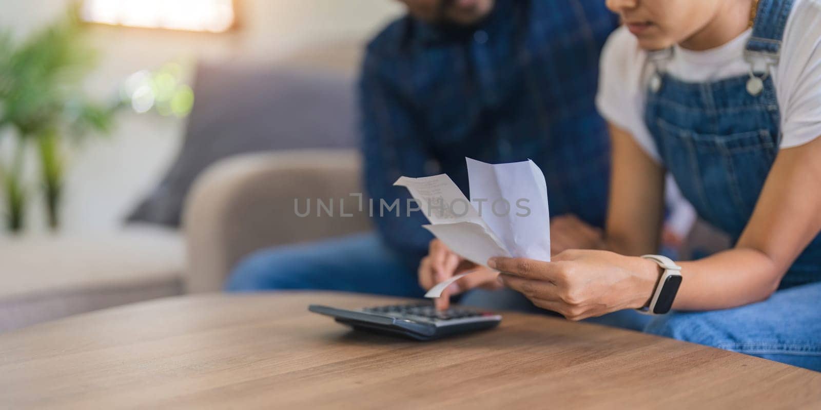 Close up of indian couple hand calculate budget or expense by hold bill at home concept of investment, budget calculation and financial plan.