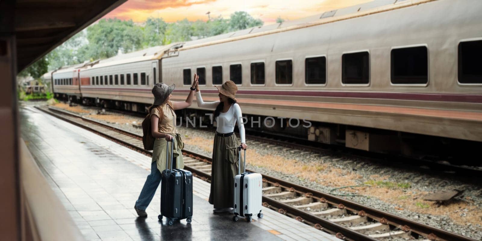 Young two woman happy with life with suitcase waiting for a train tourist adventure holiday traveling as the background concept transport lifestyle active journey and travel lifestyle