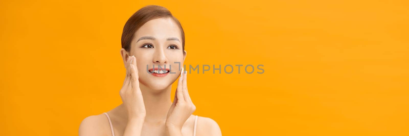 Beauty woman cleaning her face with cotton swab pad isolated on banner background by makidotvn