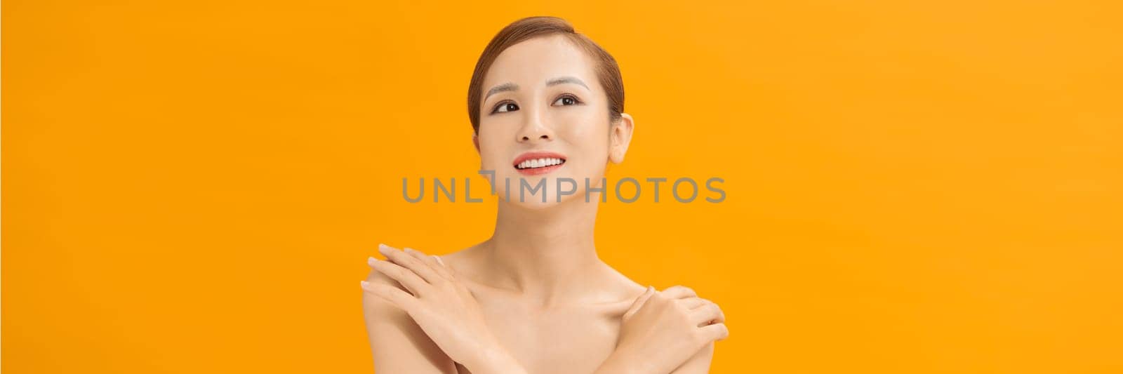 Banner of beauty smiling asian woman applying a lotion to her arm skin during her dressing up by makidotvn