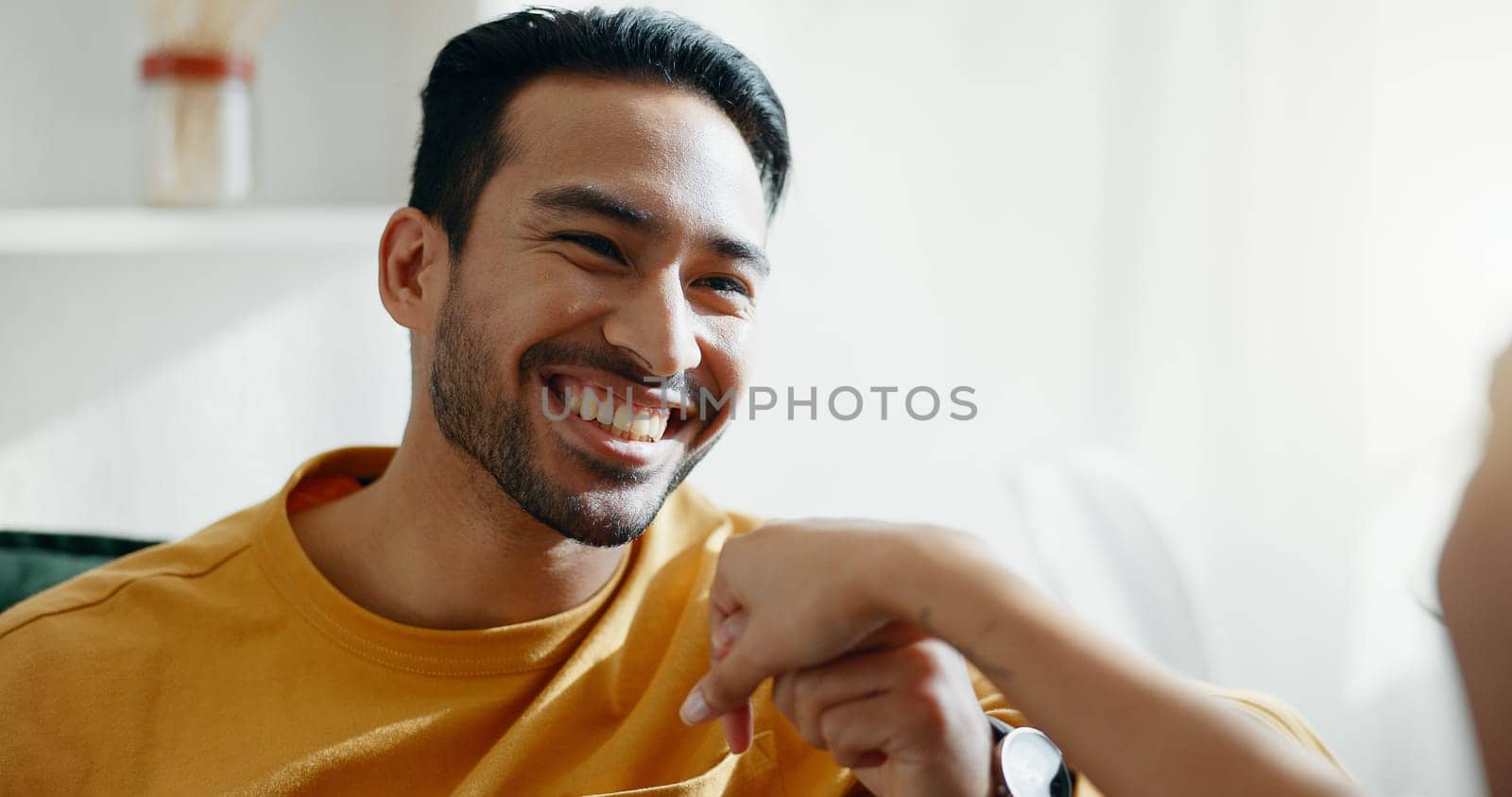 Holding hands, smile and couple on a sofa, relax and bond with conversation, romance and care at home. Happy, love and man in a living room with trust, support and smile while speaking in a house.