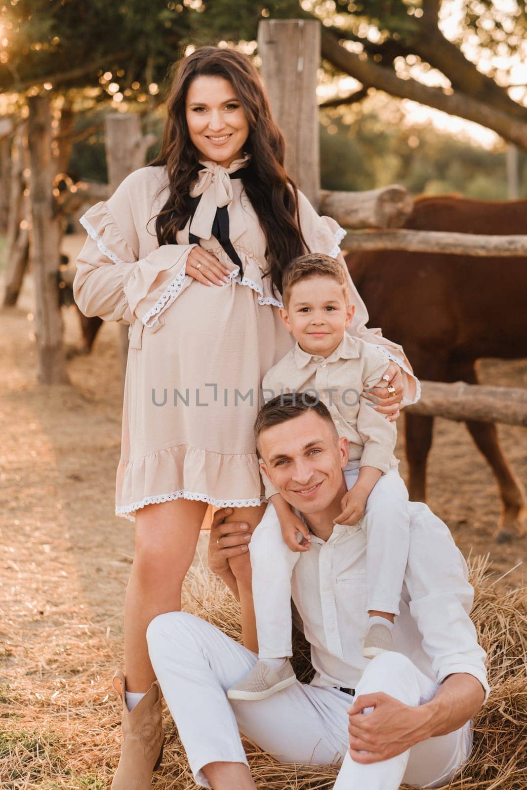 Happy family near horses at a farmer's ranch at sunset.