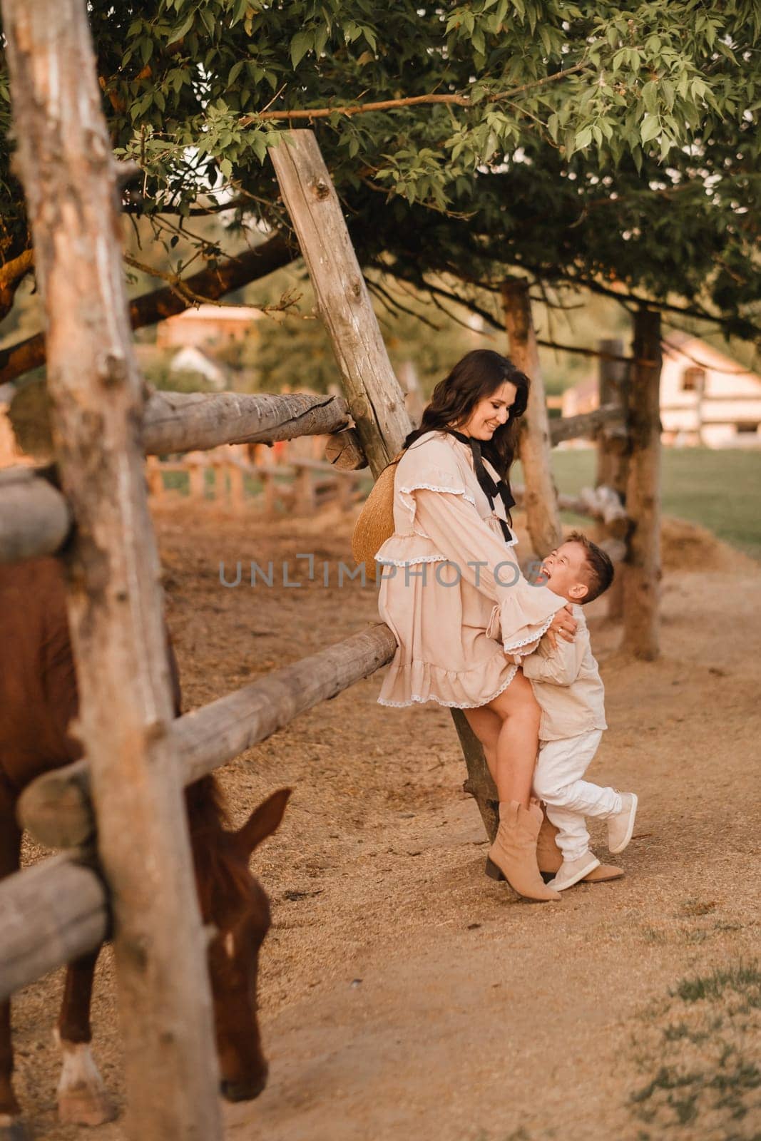 A pregnant woman with her son walks in the countryside in the summer.