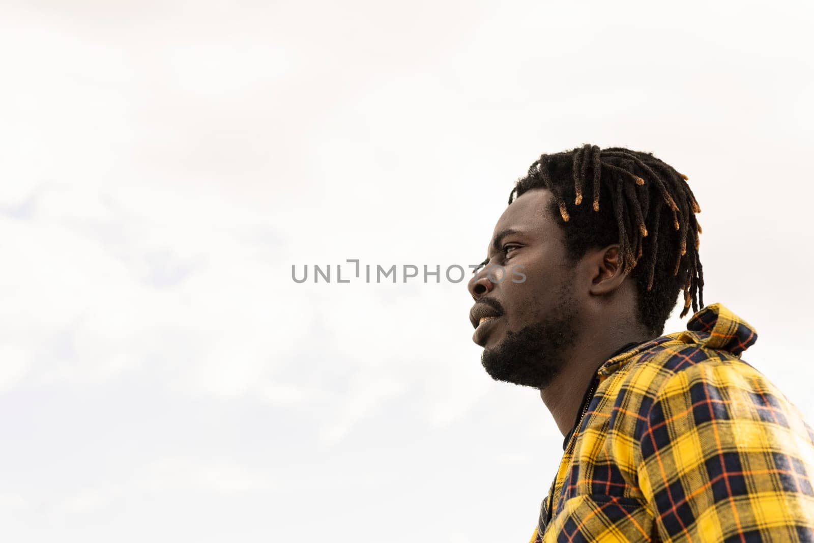 profile portrait of a black man with the sky in the background, lifestyle concept, copy space for text