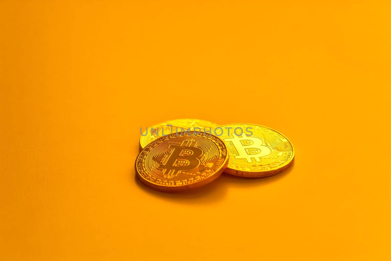 Three yellow bitcoin beans laying on flat surface.