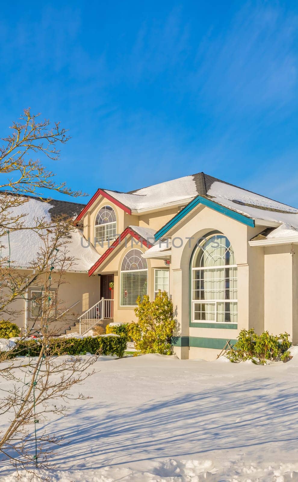 Luxury residential house with front yard in snow. Femily house decorated for christmas celebration on winter sunny day