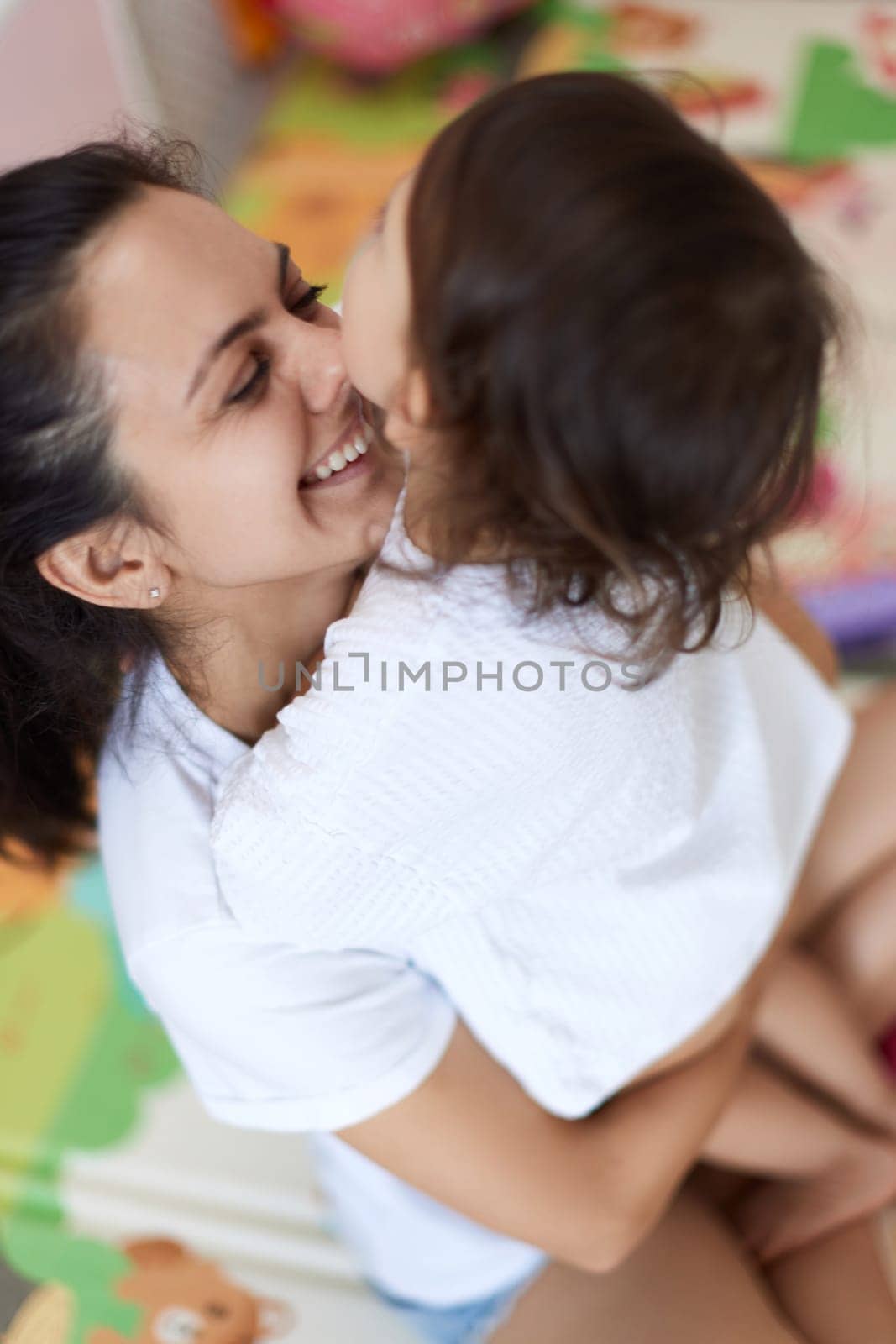 happy mother with cute baby girl in white t-shirt having fun together