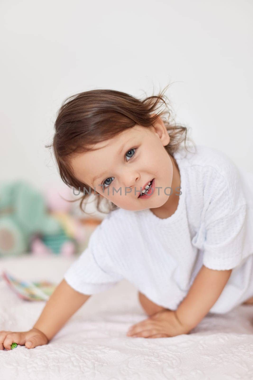 smiling cute little baby girl in white t-shirt playing in her room