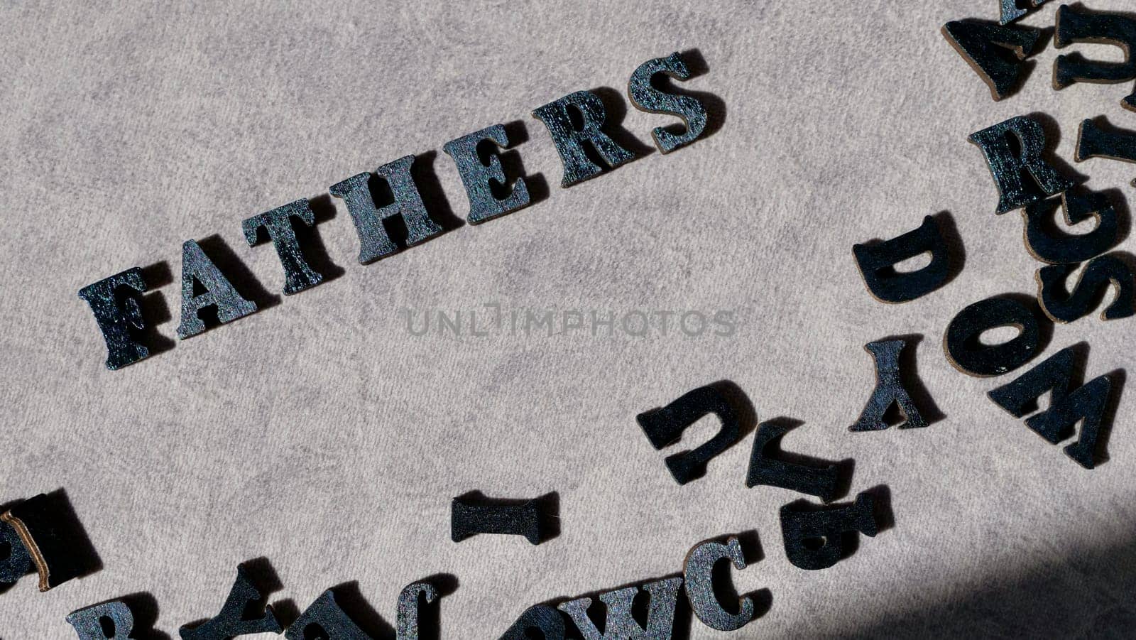 Lettering father in black letters on grey background on father's day close-up