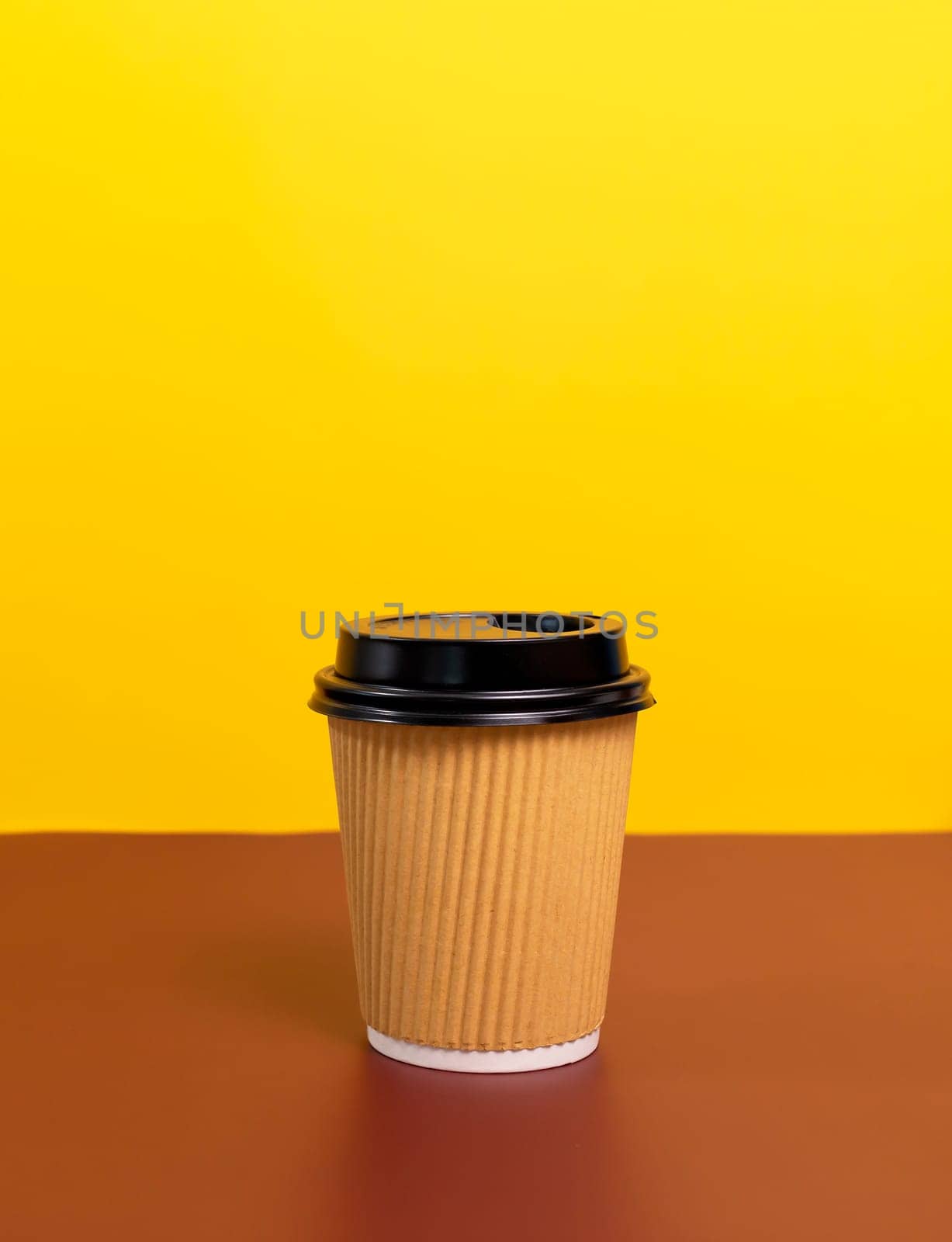 Mockup Brown Beige Paper Drinks Mug, Cup with Black Lid On Brown Yellow Background. Copy Space. On the Go Food Service Application. Vertical Plane, Eco Hot Beverage Tumbler High quality photo