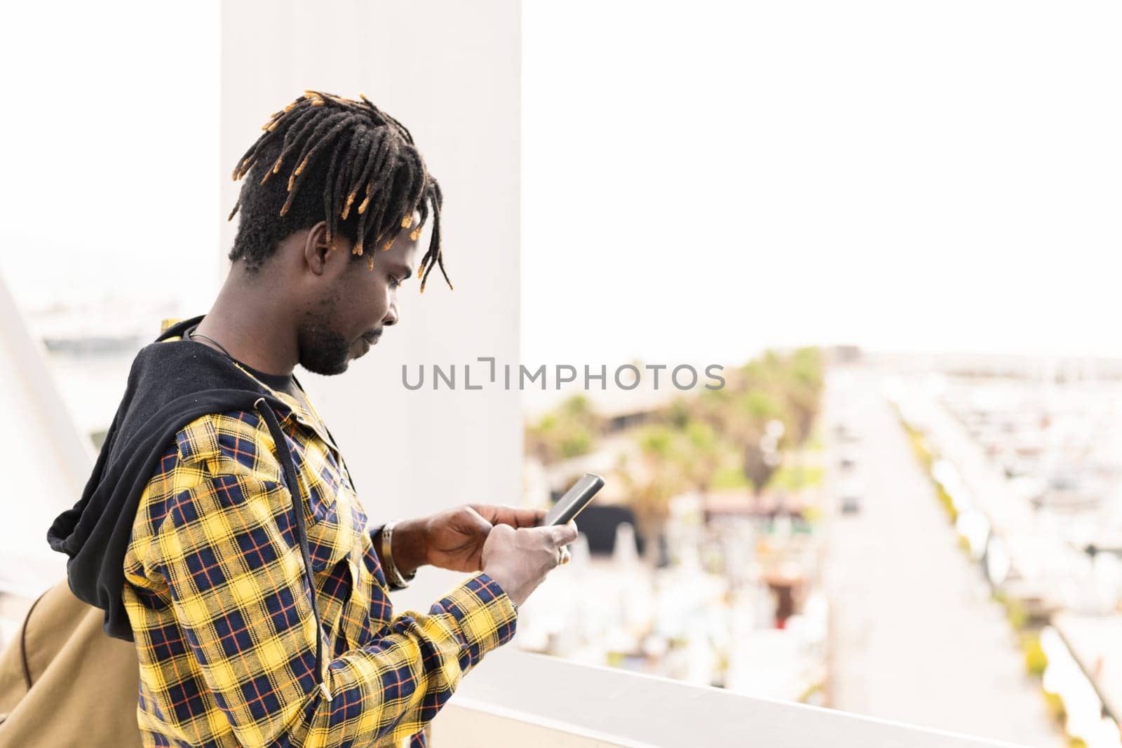 african man consulting smartphone at the city, lifestyle concept and technology