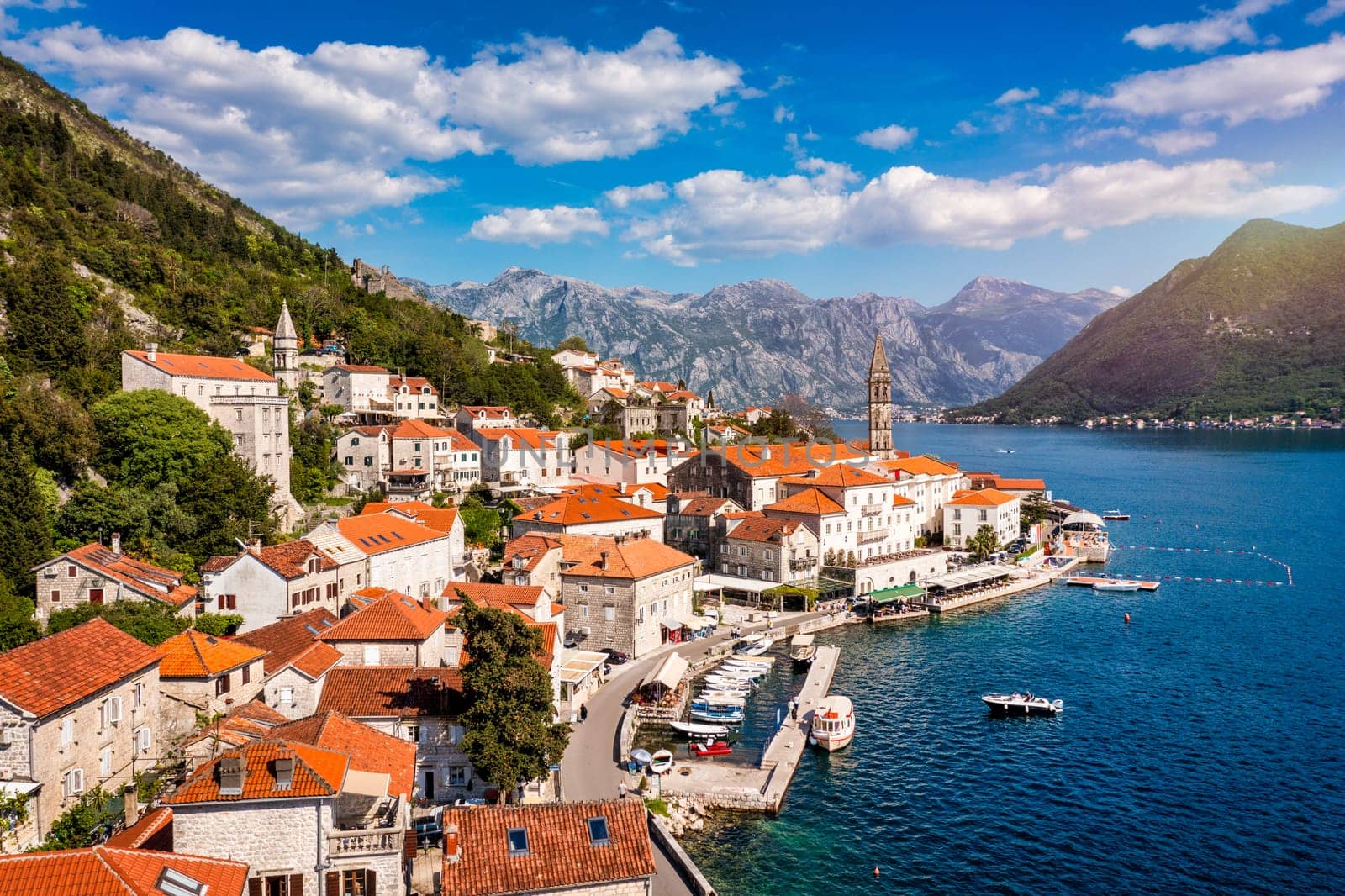 View of the historic town of Perast at famous Bay of Kotor on a beautiful sunny day with blue sky and clouds in summer, Montenegro. Historic city of Perast at Bay of Kotor in summer, Montenegro.