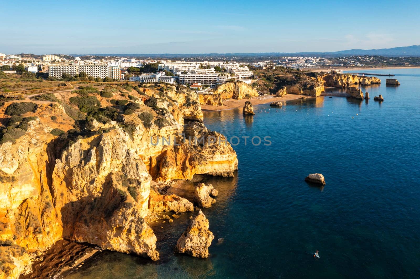Panoramic view, Ponta da Piedade near Lagos in Algarve, Portugal. Cliff rocks and tourist boat on sea at Ponta da Piedade, Algarve region, Portugal. Ponta da Piedade, Algarve region, Portugal.