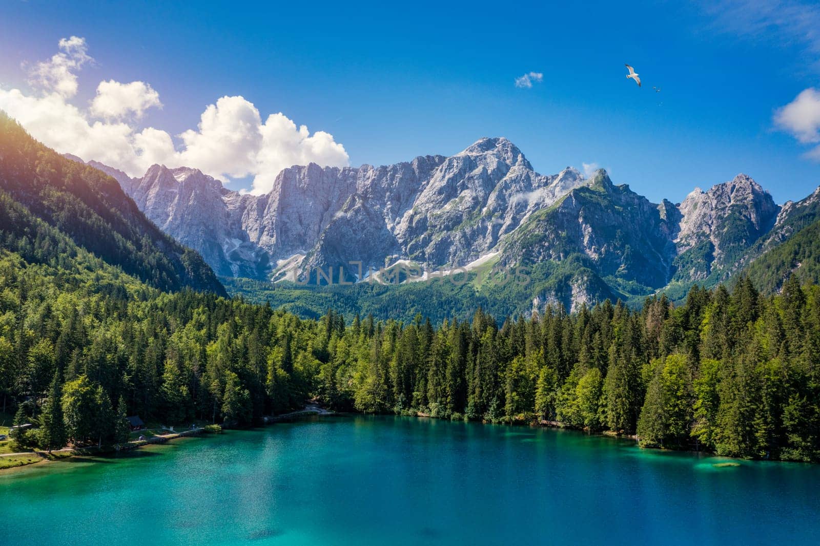 Picturesque lake Lago Fusine in Italy. Fusine lake with Mangart peak on background. Popular travel destination of Julian Alps. Location: Tarvisio comune , Province of Udine, Italy, Europe.
