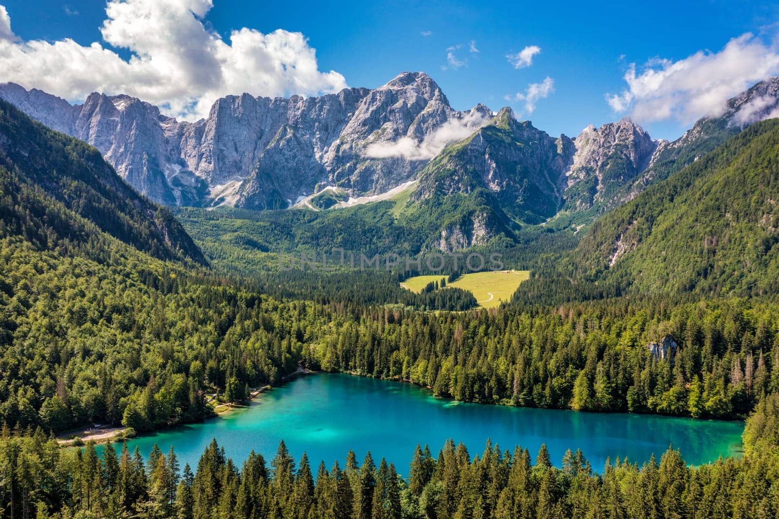 Picturesque lake Lago Fusine in Italy. Fusine lake with Mangart peak on background. Popular travel destination of Julian Alps. Location: Tarvisio comune , Province of Udine, Italy, Europe.