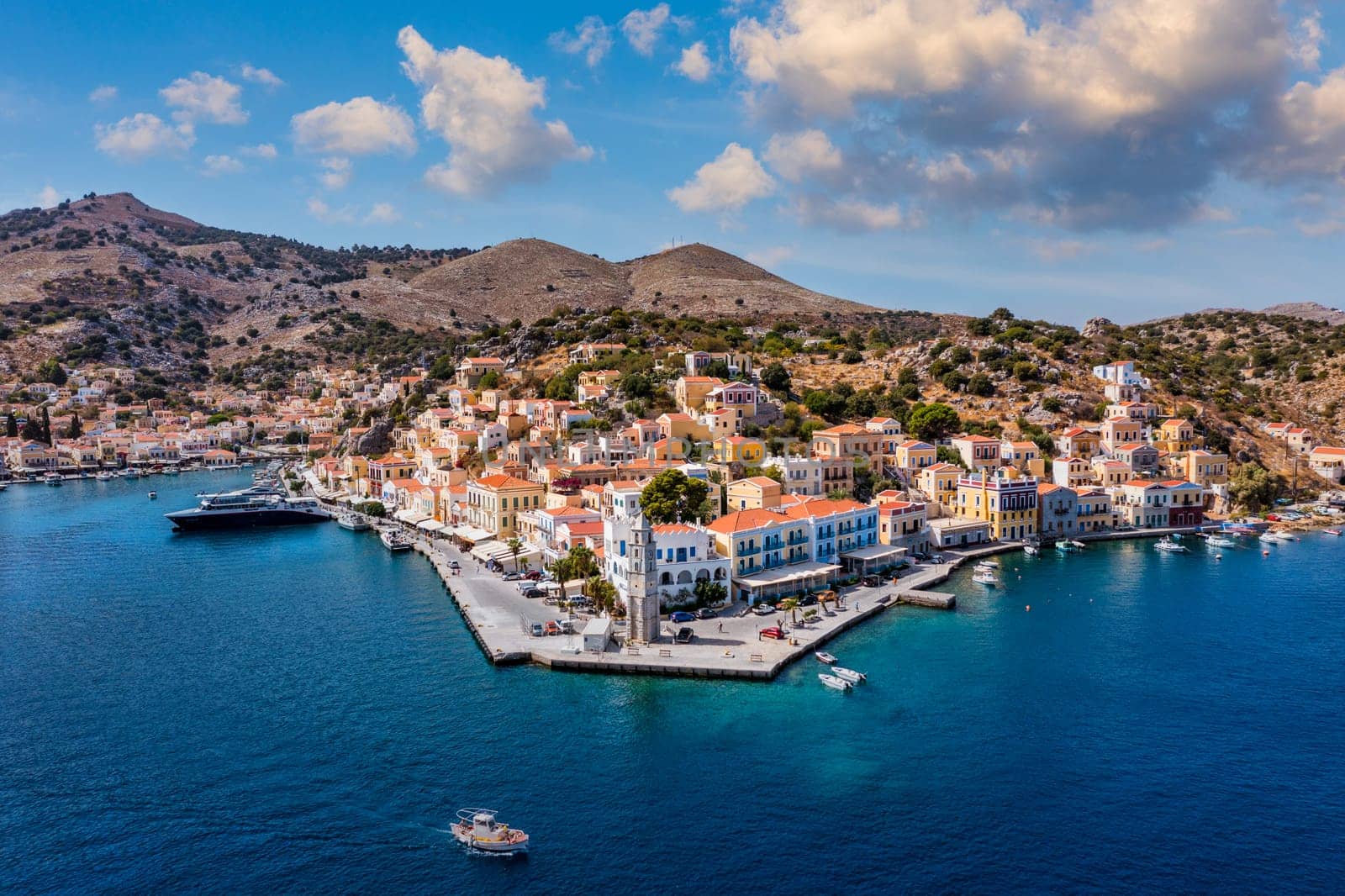 View on Symi (Simi) island harbor port, classical ship yachts, houses on island hills, Aegean Sea bay. Greece islands holidays vacation travel tours from Rhodos island. Symi, Greece,  Dodecanese.