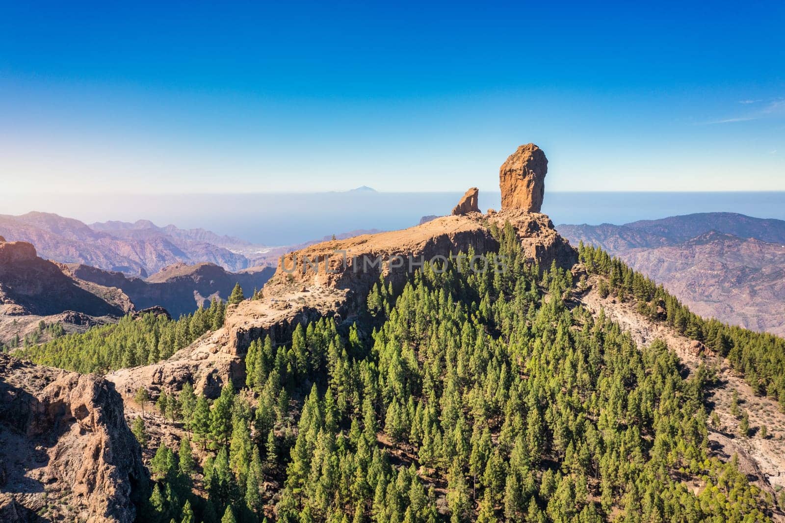 Roque Nublo and Pico de Teide in the background on Gran Canaria Island, Spain. Panoramic view of Roque Nublo sacred mountain, Roque Nublo Rural Park, Gran Canary, Canary Islands, Spain.