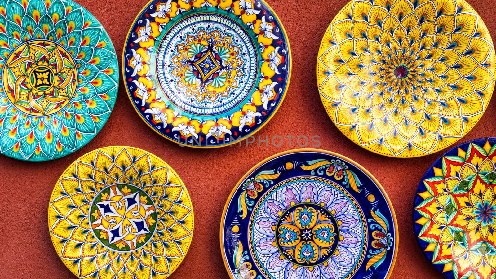 Collection of colorful Italian ceramic pottery, local craft products from Positano, Italy. Ceramic plates display in Positano, Italy. Colorful of vintage ceramic plates in Positano, Italy.