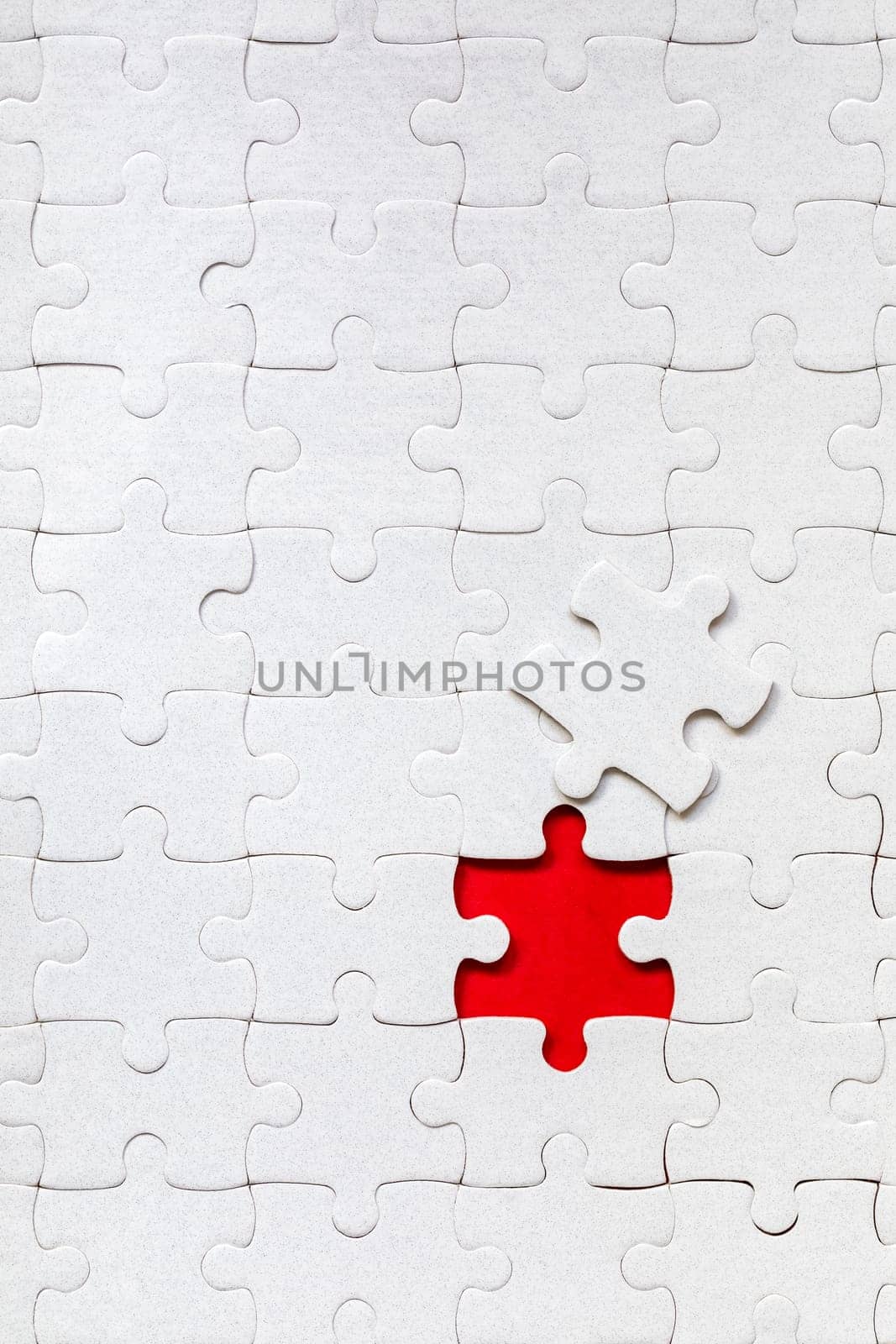 White jigsaw puzzle. White puzzle pieces on color background. Unfinished white jigsaw puzzle pieces on color background. 