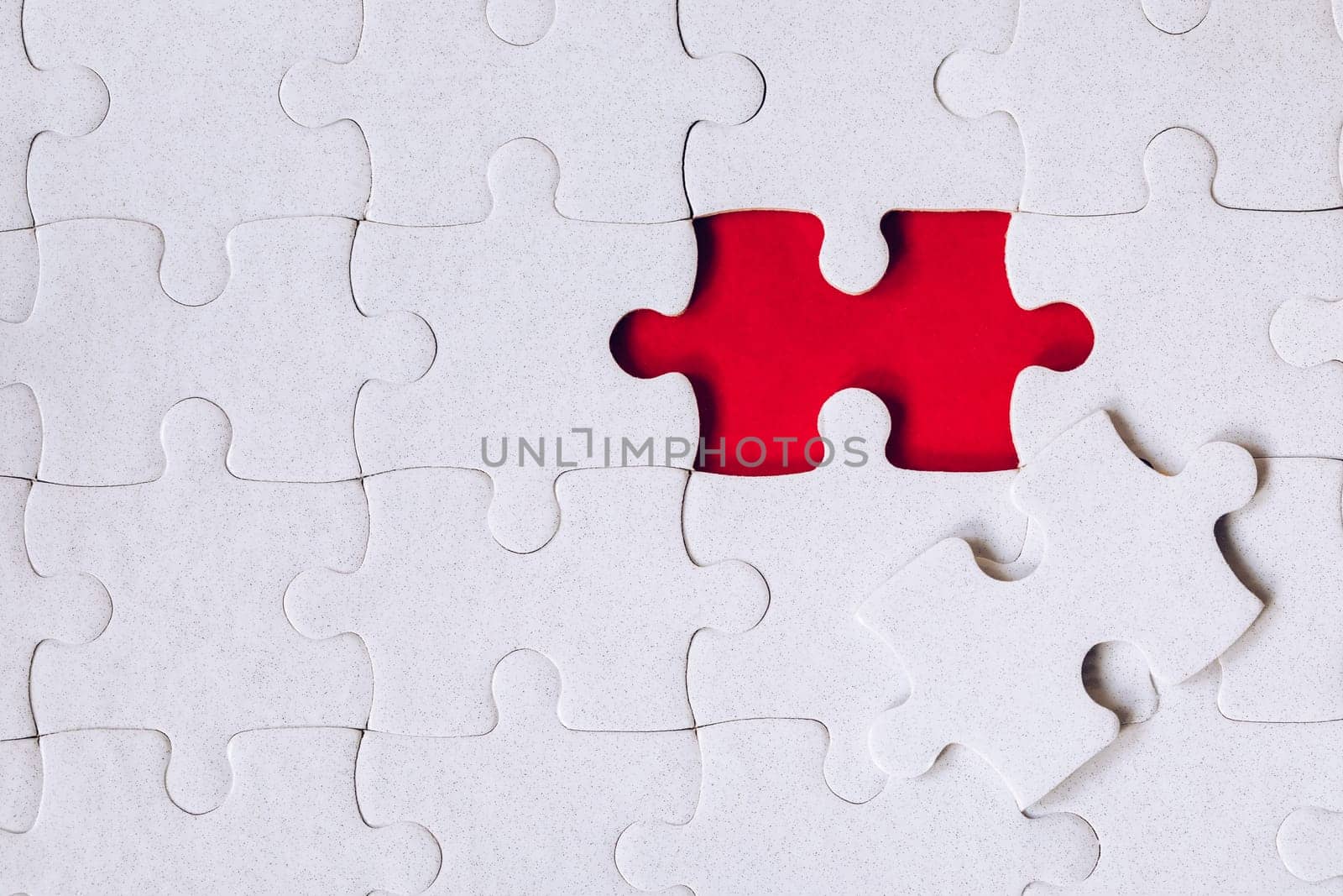 Unfinished white jigsaw puzzle pieces. Fill in pieces of the jigsaw puzzle. Complete the jigsaw puzzle with the missing pieces. Fragment of a folded white jigsaw puzzle.