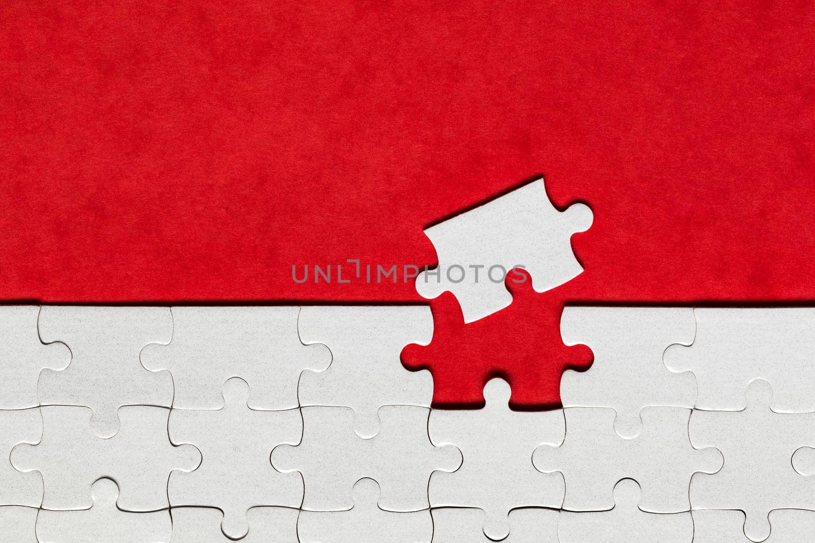 White jigsaw puzzle pieces. Fill in pieces of the jigsaw puzzle. Complete the jigsaw puzzle with the missing pieces. Fragment of a folded white jigsaw puzzle.