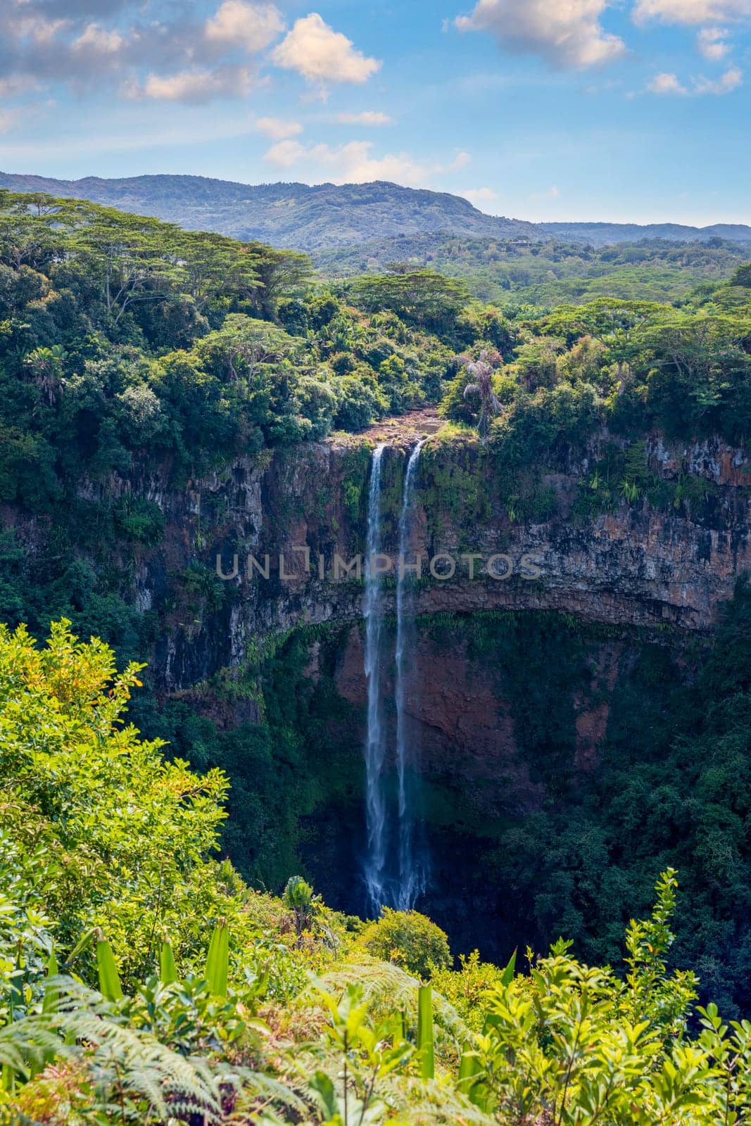 The highest waterfall on the island of Mauritius is Chamarel, whose water falls into the crater of a long-extinct volcano. Exotic nature of tropical paradise of Mauritius island, Chamarel waterfall.