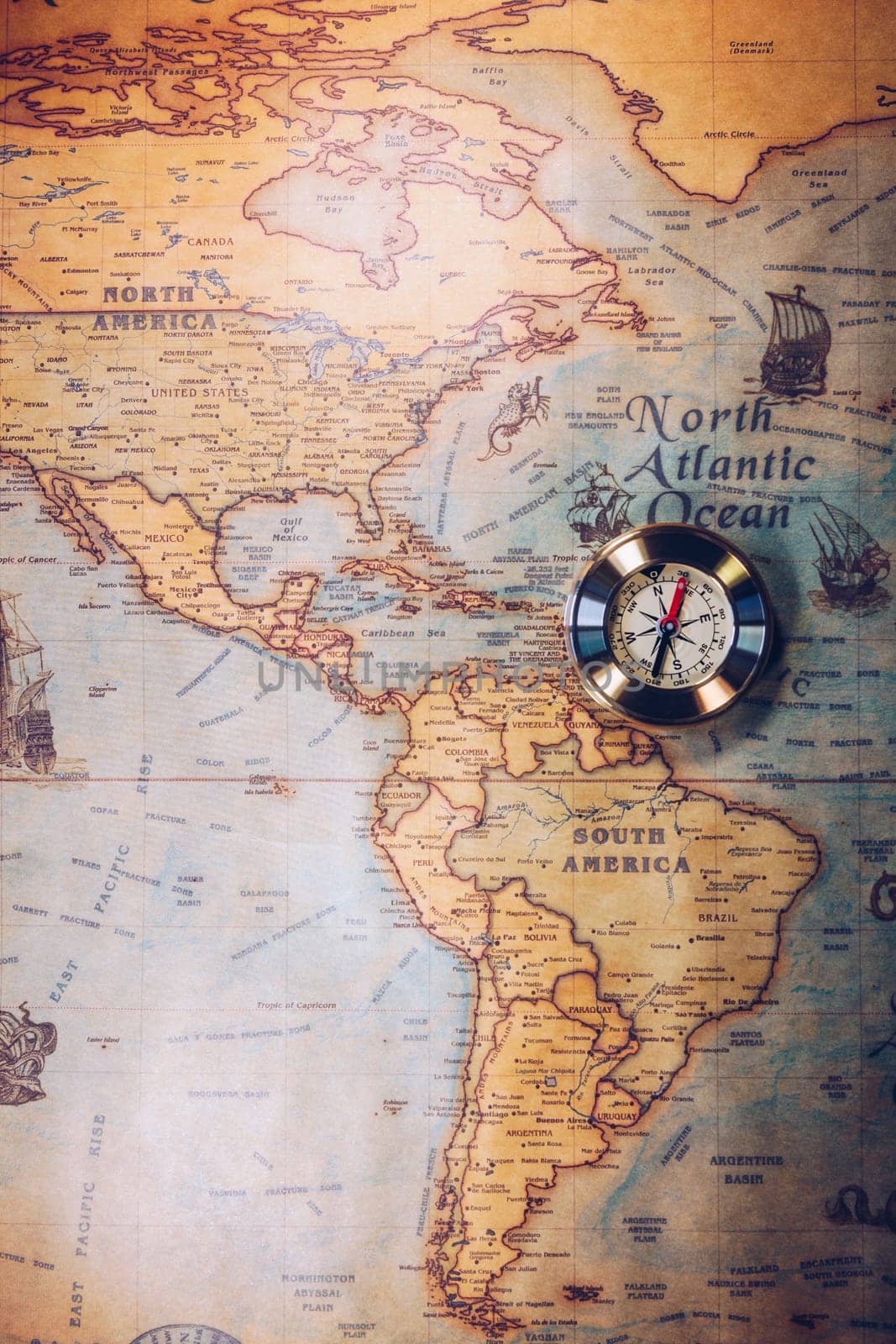 Old vintage retro golden compass on ancient map. Selective focus, shallow depth of field. Concept of world travel, sightseeing and tourism.
