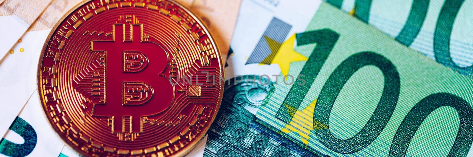 Golden bitcoin over Euro money. Bitcoin cryptocurrency. Crypto currency concept. Bitcoin with euro bills. Bitcoins stacked on euro banknotes.