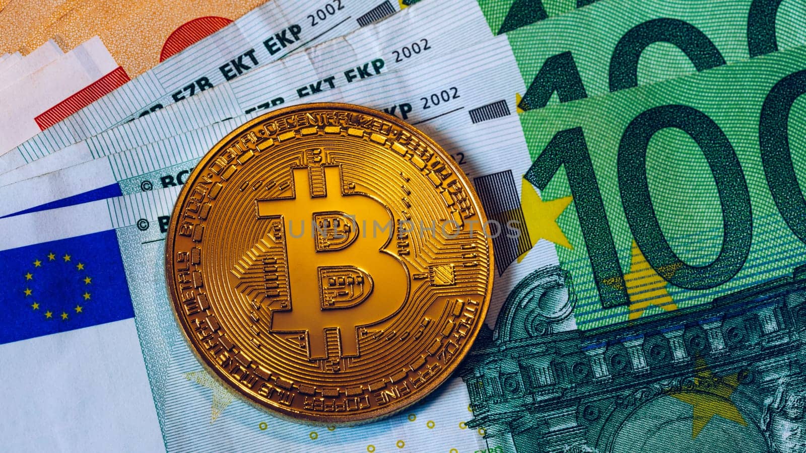Golden bitcoin over Euro money. Bitcoin cryptocurrency. Crypto currency concept. Bitcoin with euro bills. Bitcoins stacked on euro banknotes.