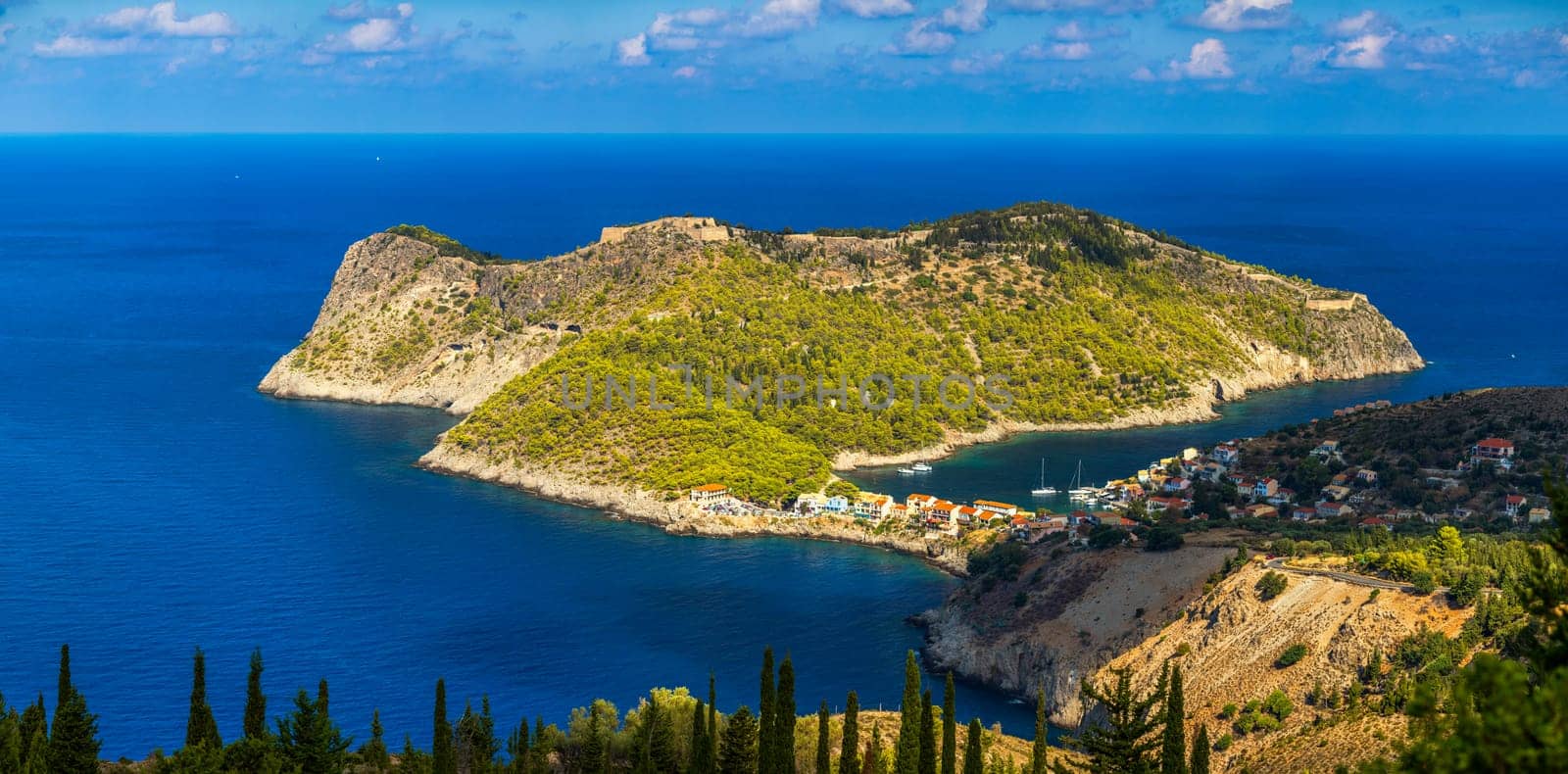 Assos village in Kefalonia, Greece. Turquoise colored bay in Mediterranean sea with beautiful colorful houses in Assos village in Kefalonia, Greece, Ionian island, Cephalonia, Assos village.