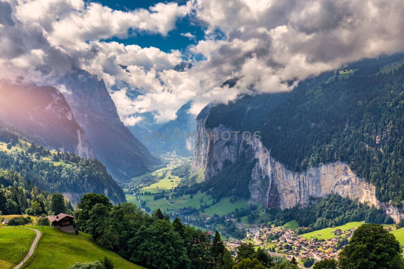 Amazing summer landscape of touristic alpine village Lauterbrunnen with famous church and Staubbach waterfall. Location: Lauterbrunnen village, Berner Oberland, Switzerland, Europe.