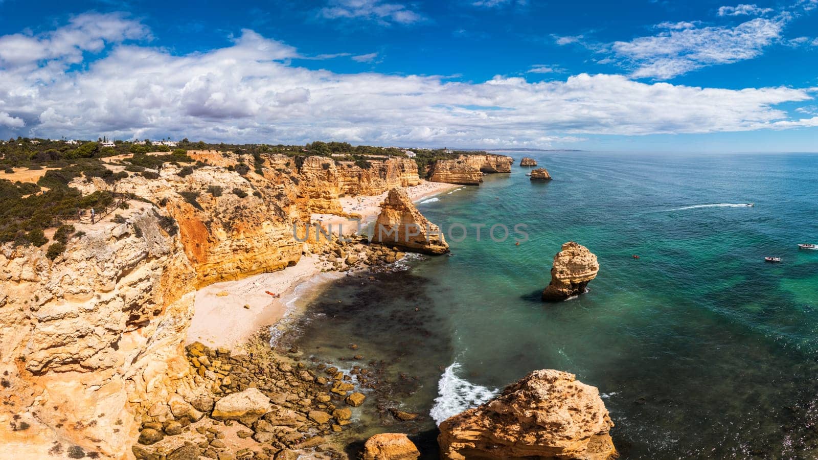 Praia da Marinha, beautiful beach Marinha in Algarve, Portugal. Navy Beach (Praia da Marinha) with flying seagulls over the beach, located on the Atlantic coast in Lagoa Municipality, Algarve.