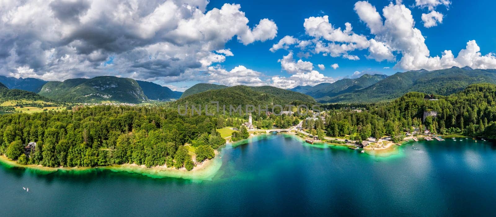 Aerial view of Bohinj lake in Julian Alps. Popular touristic destination in Slovenia. Bohinj Lake, Church of St John the Baptist. Triglav National Park, Julian Alps, Slovenia. 