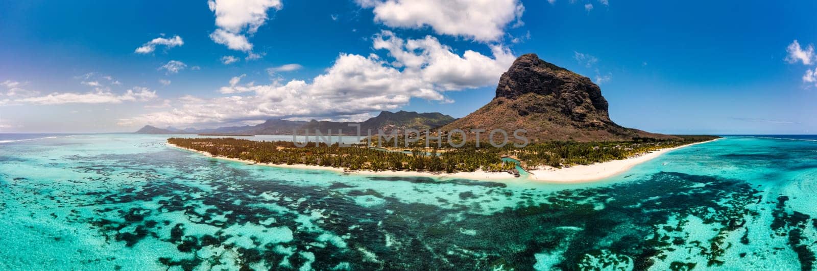 Beach with palm trees and umbrellas on Le morne beach in Mauriutius. Luxury tropical beach and Le Morne mountain in Mauritius. Le Morne beach with palm trees, white sand and luxury resorts, Mauritius