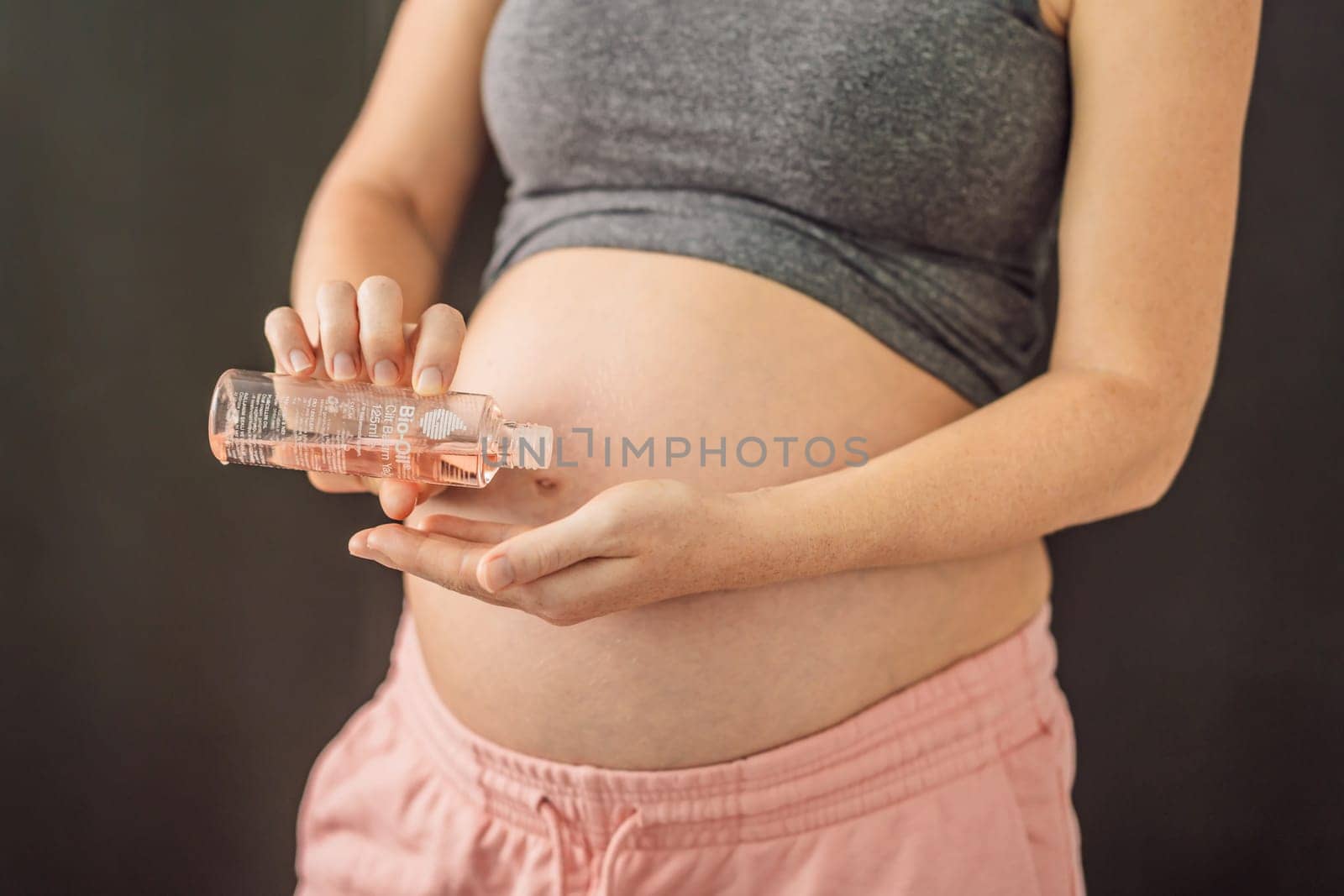 Turkiye, Antalya 02.02.2022: Woman holds Bio Oil, a nurturing choice for pregnant women. A soothing image of care and wellness during pregnancy by galitskaya