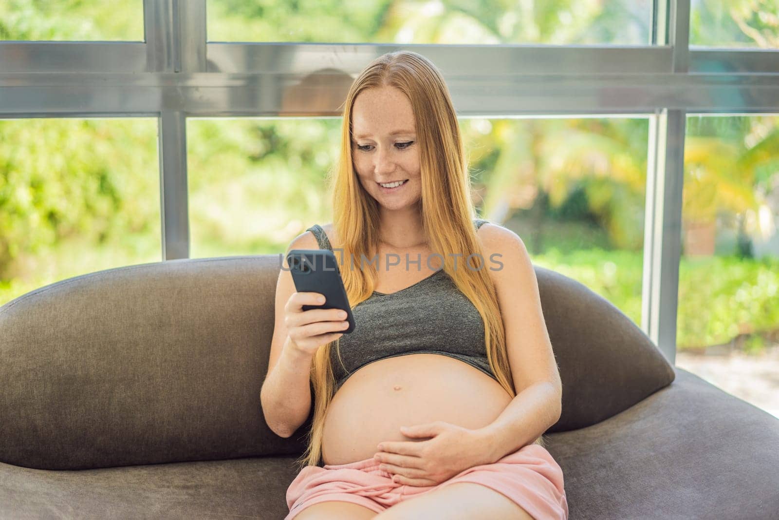 Mobile pregnancy online maternity application. Pregnant mother using phone. Pregnancy, medicine, pharmaceutics, health care and people concept.